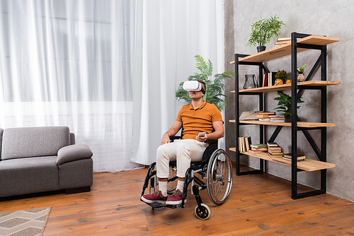 handicapped man gaming in vr headset while sitting in wheelchair at home