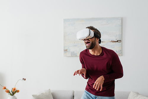 adult man grimacing and gesturing while gaming in vr headset