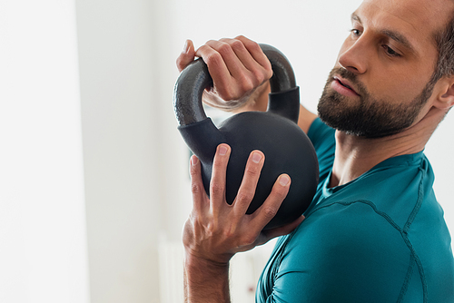 adult athletic man training with kettlebell at home