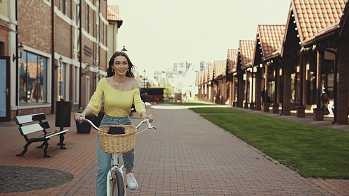 pretty woman riding bicycle on urban street