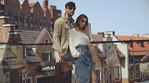 stylish couple in sunglasses posing outside