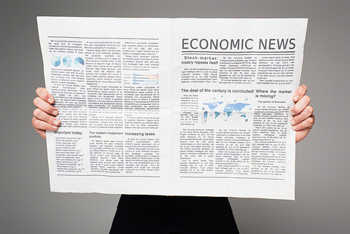 man covering face while reading economic news isolated on grey
