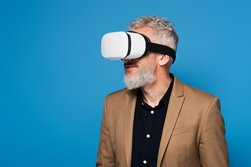 bearded middle aged man in vr headset isolated on blue