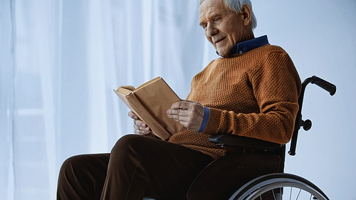 senior man sitting in . and reading book at retirement home