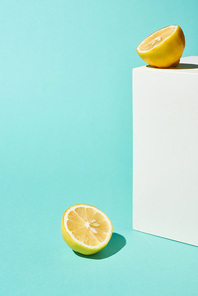 bright lemon halves and white cube on turquoise background