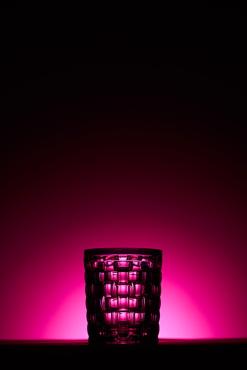 transparent textured glass on dark background with pink illumination