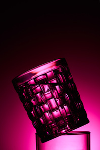 close up view of transparent textured glass on dark background with pink illumination