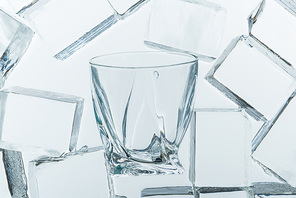 top view of transparent clear square ice cubes and empty glass on mirror