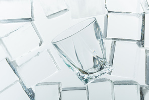 top view of transparent clear square ice cubes and empty glass on mirror