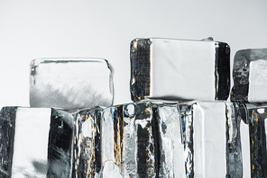 close up view of melting transparent clear square ice cubes isolated on white