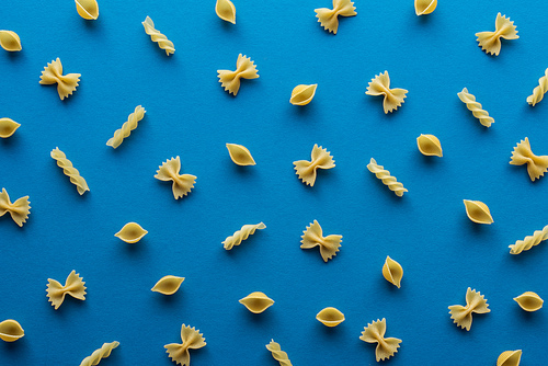top view of different uncooked pasta on blue background