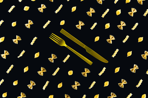 flat lay of different kinds of pasta with plastic yellow fork and knife in middle isolated on black