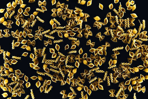 top view of mixed uncooked pasta isolated on black
