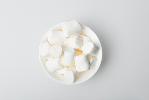 top view of soft and puffy marshmallows in bowl on white