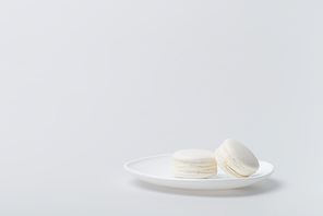 delicious macarons on plate isolated on white