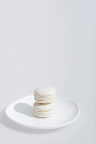 tasty and sweet macarons on plate isolated in white