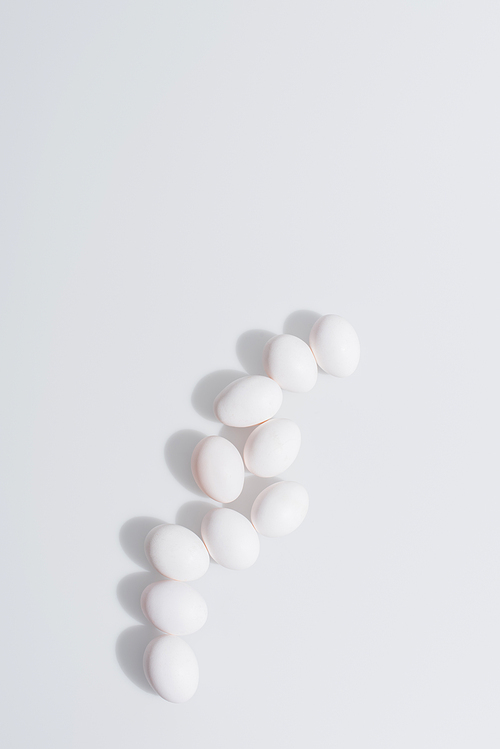 top view of raw and organic eggs in shell on white background