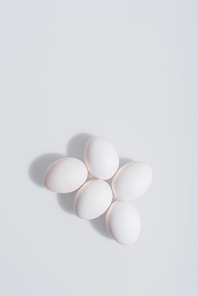 top view of uncooked and organic eggs in shell on white background
