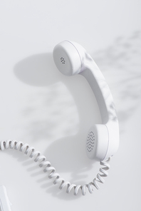top view of shadows on retro telephone handset on white