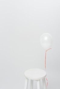 lightweight balloon near wooden chair isolated on white