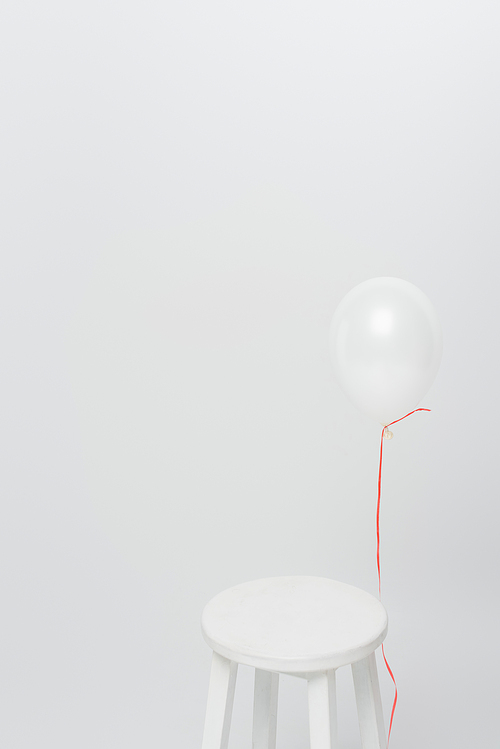 lightweight balloon near wooden chair isolated on white