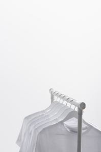 trendy t-shirts hanging on clothes rack isolated on white