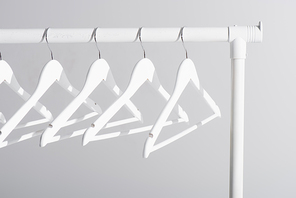 white hangers on clothes rack isolated on grey