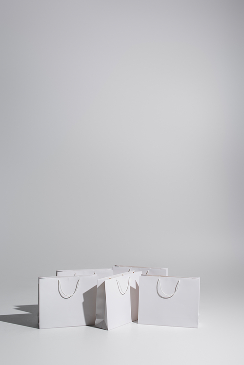 white shopping bags with purchases on grey background