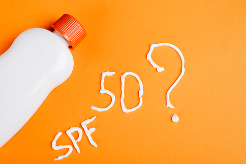 top view of sunscreen near spf lettering, number fifty and question mark on orange background