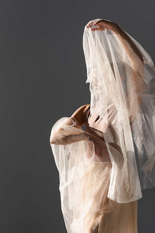 Young ballerina dancing with white cloth isolated on grey