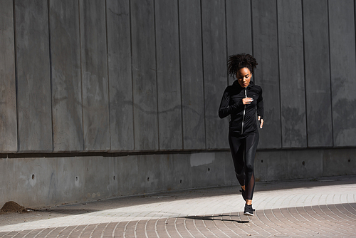 African american woman jogging on urban street