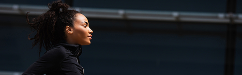 Side view of african american sportswoman looking away outdoors, banner