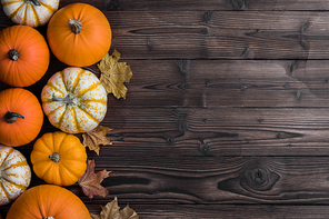 many pumpkins and maple leaves on dark wooden background,  concept