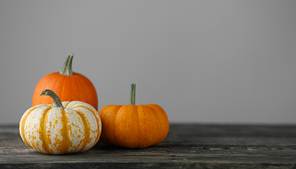three pumpkins on wooden table over gray background ,  concept