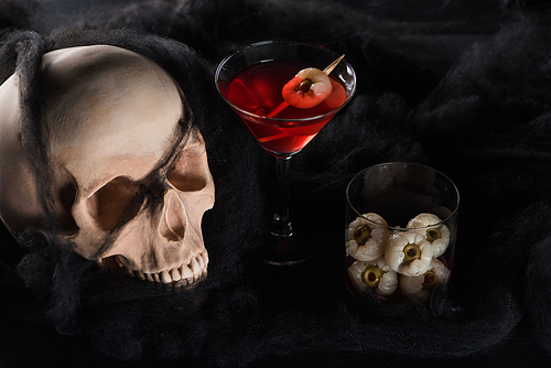 spooky skull with red cocktail on black background, Halloween decoration