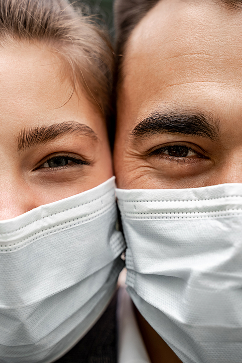 cropped view of young man and woman in medical masks 