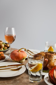whole pumpkin near grilled turkey, and glasses with rose wine isolated on grey