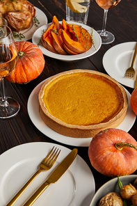 pumpkin pie and baked pumpkins served on wooden table