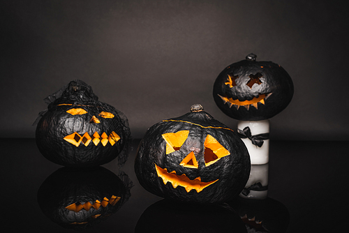 carved and dark halloween pumpkins on black background