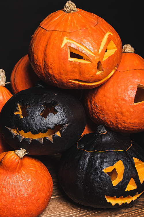 stack of carved and spooky pumpkins isolated on black