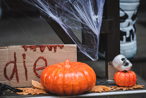 pumpkins, skull and  leaves near card with die lettering on decorated porch