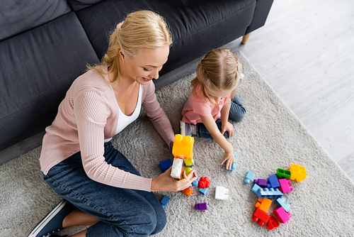 high angle view of child and mother playing with building blocks on floor