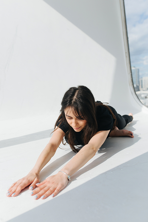 brunette armenian woman meditating on white floor at home