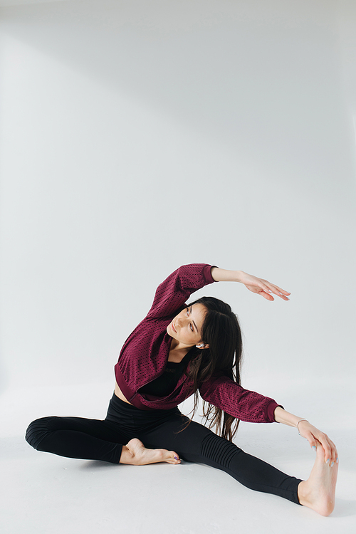 sportive armenian woman practicing yoga in seated side bend pose