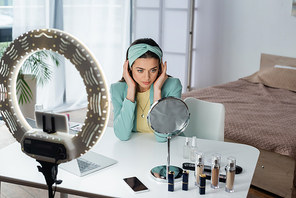 beauty blogger preparing for record near cosmetics, gadgets and ring lamp