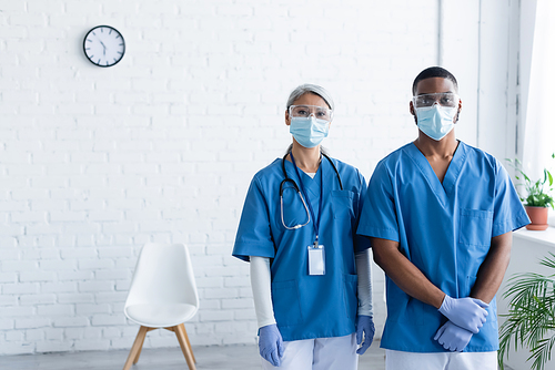 multicultural doctors in uniform and medical masks  in vaccination center