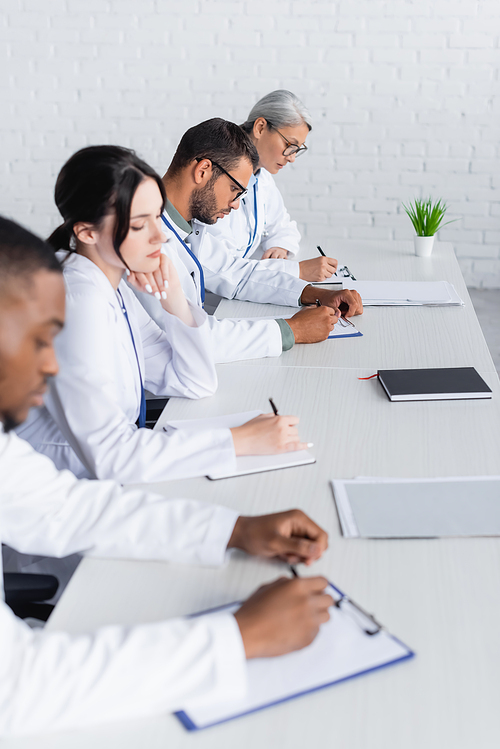 multiethnic doctors working with documents in hospital conference room