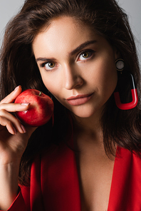 stylish woman holding red apple isolated on grey
