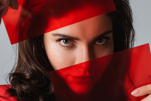 young woman  through red glass isolated on grey