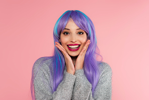 Excited woman with dyed hair and warm sweater  isolated on pink